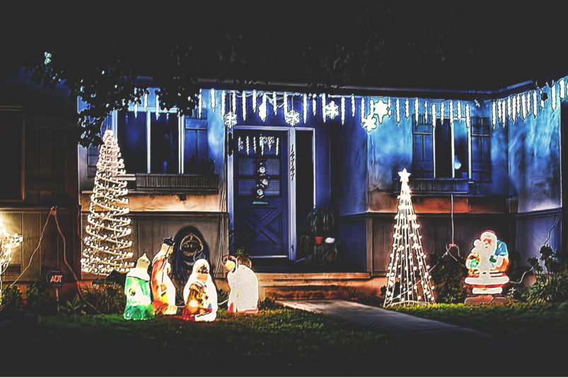 House decorated with Christmas lights and trees