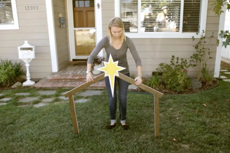woman-setting-up-manger-scene-outside-house