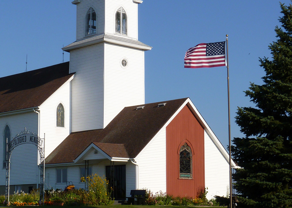 Flagpole with American flag in front of church